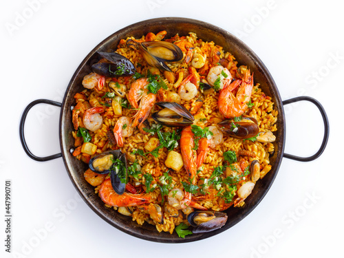 Traditional spanish seafood paella with rice, mussels, shrimps in a pan on white background. view from above, flat lay © BooFamily