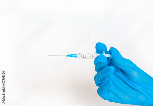 The doctor holds a vaccination syringe on a white background. A shot from the coronovirus. Vaccination against dangerous infections or treatment of diseases
