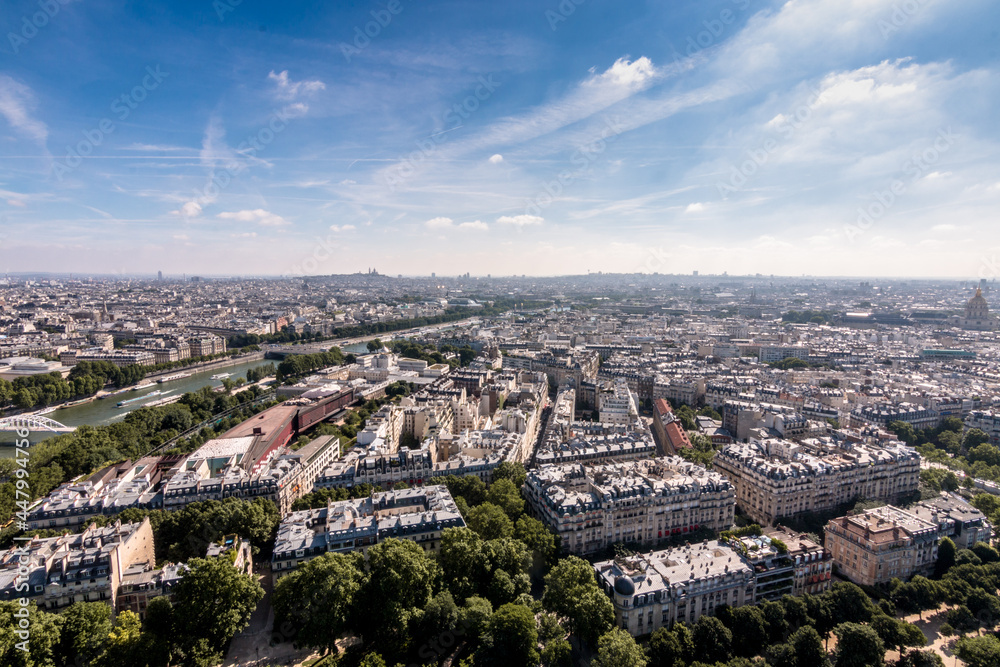 aerial view of the city of paris on a summer day with a background of clouds