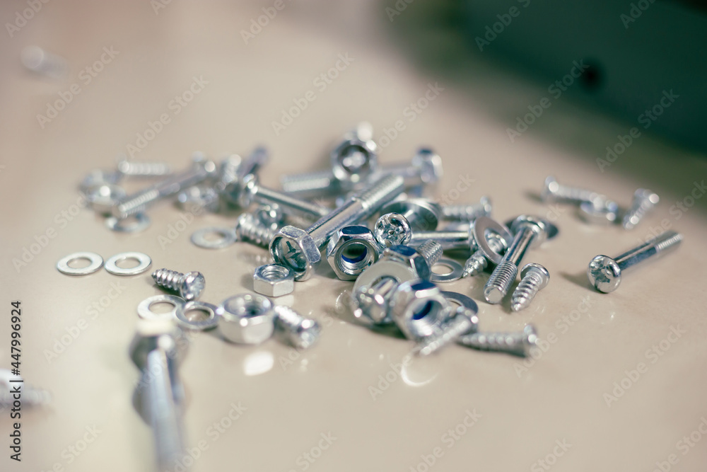 Group of metal products, bolts, nuts, steel washers on the floor Group of metal products, bolts, nuts, steel washers on the floor
