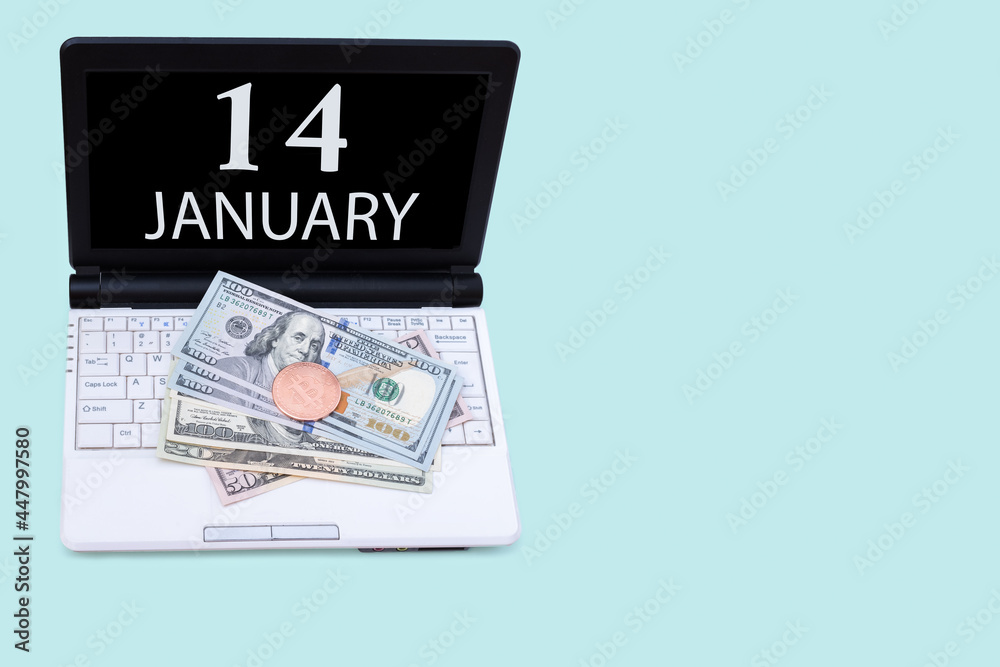 Laptop with the date of 14 january and cryptocurrency Bitcoin, dollars on a blue background. Buy or sell cryptocurrency. Stock market concept. Laptop with the date of 14 january and cryptocurrency Bitcoin, dollars on a blue background. Buy or sell cryptocurrency. Stock market concept.