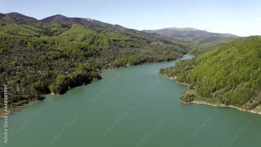 Still Lake Waters With Lush Green Hills On A Sunny Day. Maneciu Dam In Teleajen River, Prahova County, Romania. aerial drone, dolly-in Still Lake Waters With Lush Green Hills On A Sunny Day. Maneciu Dam In Teleajen River, Prahova County, Romania. aerial drone, dolly-in