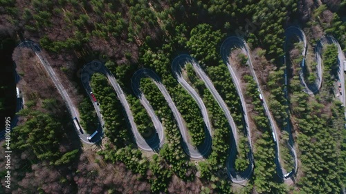 Slow aerial rise above traffic on winding road of Bratocea Pass, Romania photo