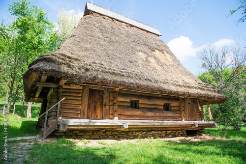 Rustic old log hut covered with thatch.