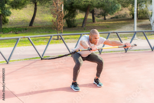 Sportsman exercising with a trx fitness strap in the park © Iván Moreno