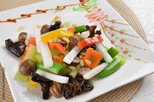 stir fried mixed green vegetables with macadamia nut, green bean, lotus root, black fungus and mushroom in white background asian halal vegan menu