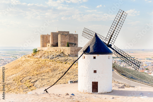 Restored antique windmill and a castle on a hill