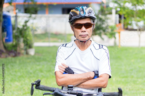 Senior man sitting on a bicycle looking at the camera