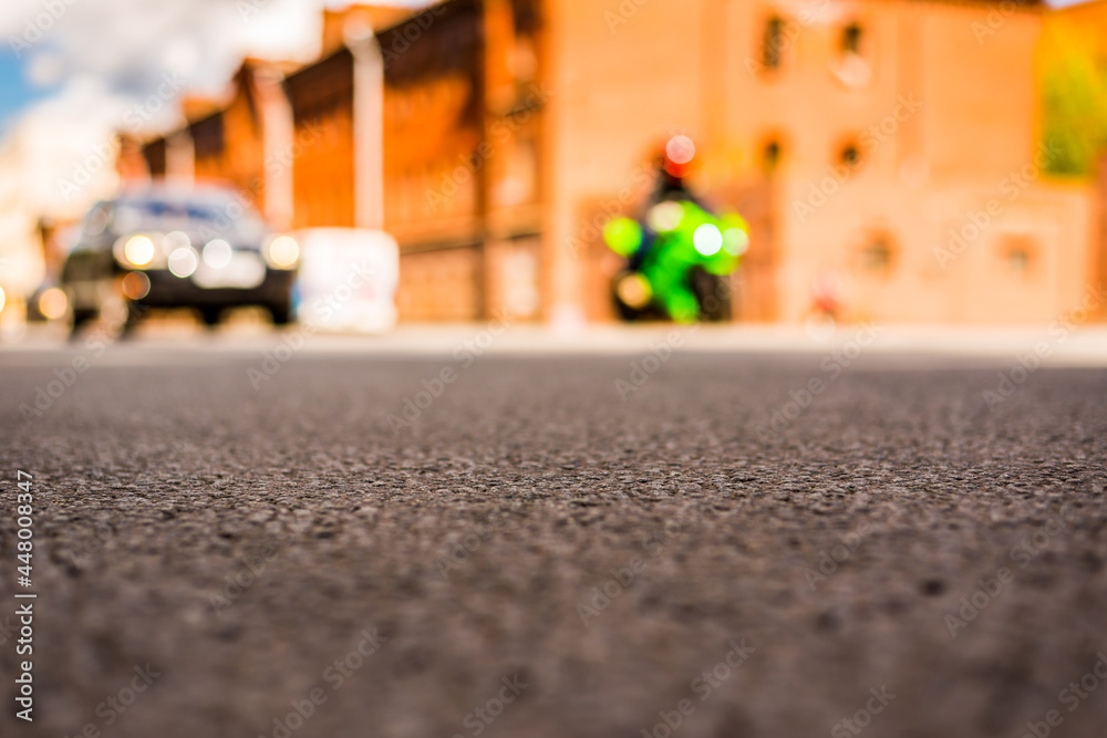 Summer in the city, the car and bike driving on empty street. Close up view  from the asphalt level