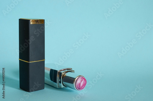 An old used tube of pink lipstick and a closed tube of lipstick
