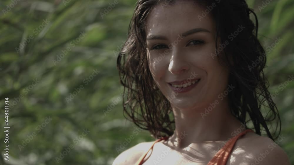 Relaxation and tranquility. A young woman looks at the camera with a smile, behind her is the rushes moved by the wind. Natural surroundings outside. Slowmotion movie. Relaxation and tranquility. A young woman looks at the camera with a smile, behind her is the rushes moved by the wind. Natural surroundings outside. Slowmotion movie.
