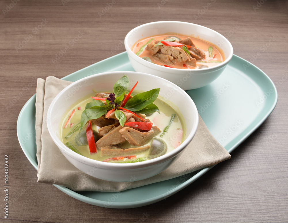 thai spicy chili red and green curry hot soup with vegetarian meat in bowl blue plate on wood background asian halal vegan menu thai spicy chili red and green curry hot soup with vegetarian meat in bowl blue plate on wood background asian halal vegan menu