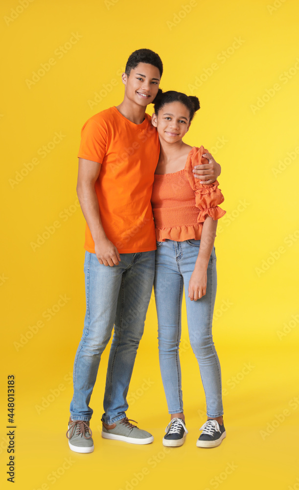 African-American brother and sister on color background African-American brother and sister on color background