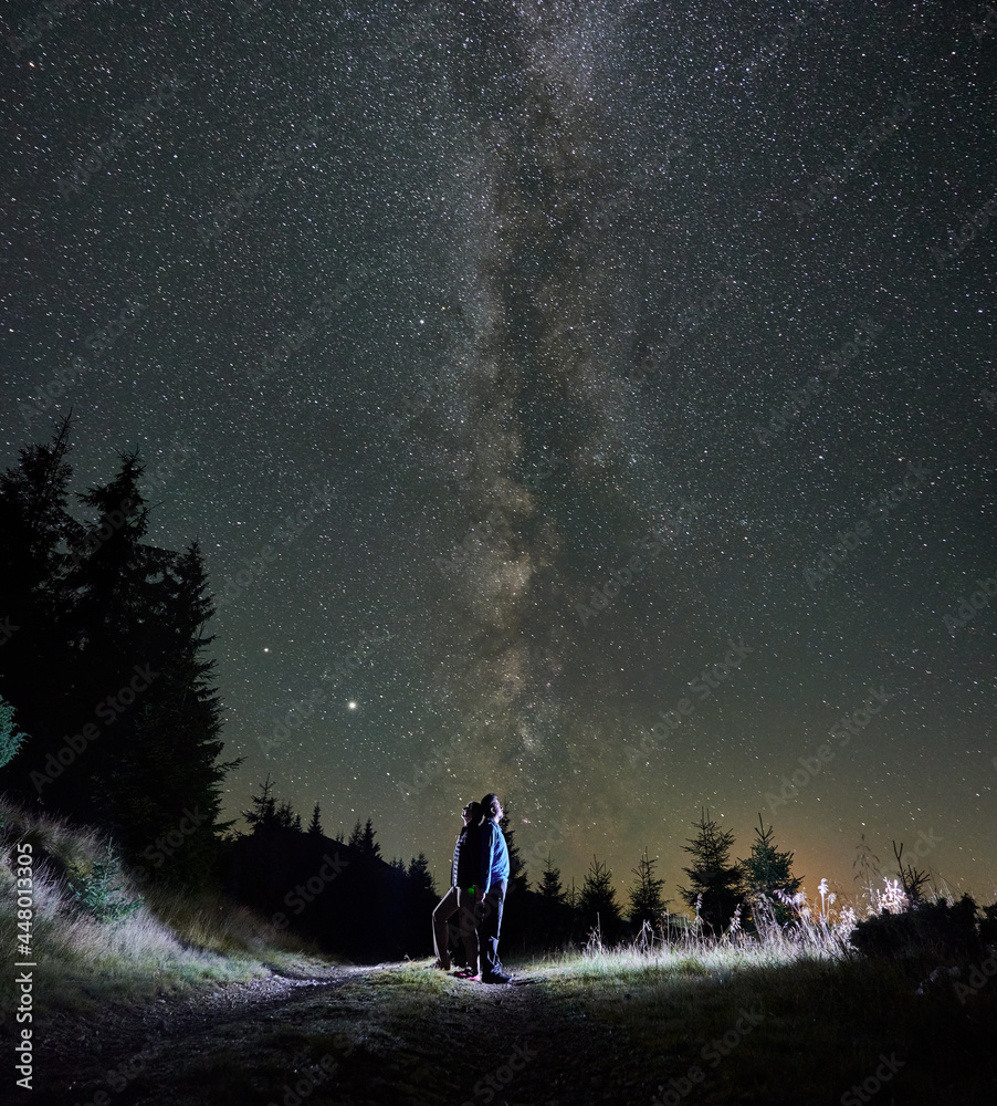 Romantic couple enjoying nature and starry sky in mountains. Concept of relaxation on nature in midnight. Romantic couple enjoying nature and starry sky in mountains. Concept of relaxation on nature in midnight.
