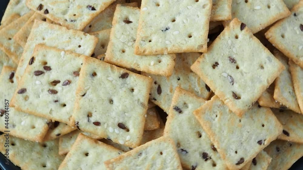 Delicious healthy cookies crackers with flax seeds and sesame seeds rotate. Background of a healthy snack food, close up Delicious healthy cookies crackers with flax seeds and sesame seeds rotate. Background of a healthy snack food, close up