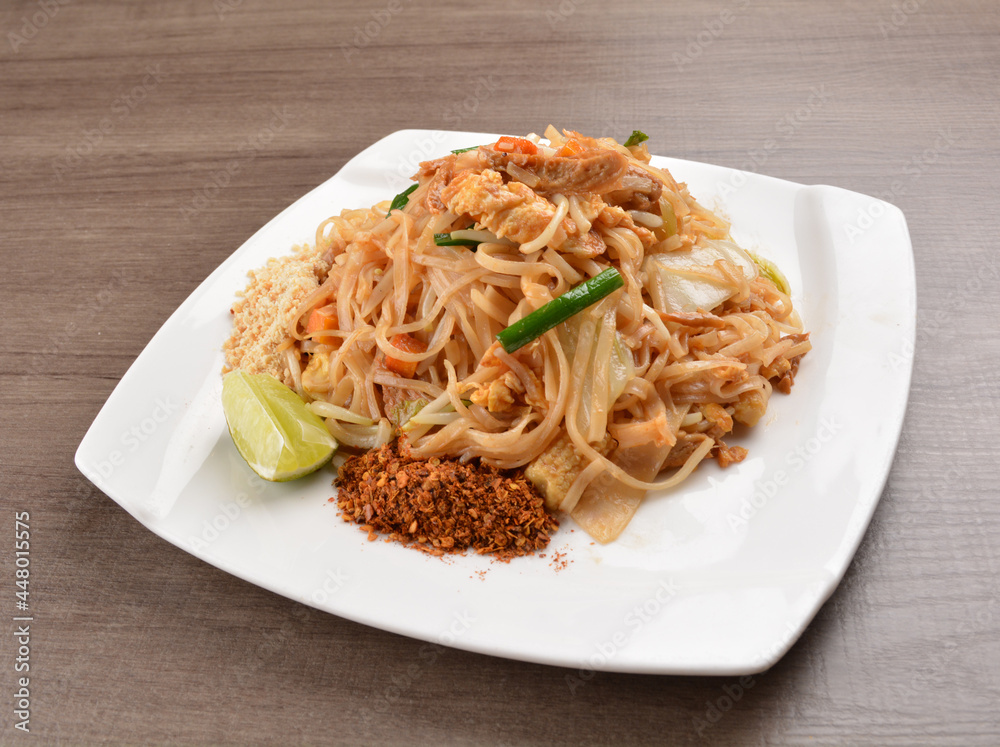 wok stir fried kway teow rice noodle mee goreng with vegetable in spicy soy chilli sauce on wood background asian halal vegan menu