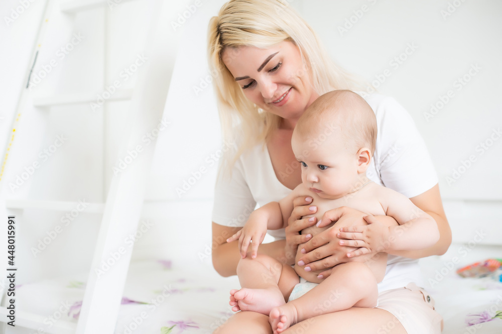 A young mother is holding her newborn baby. Mother of a nursing baby. Mother breastfeeding her baby. The family is at home. Portrait of a happy mother and child A young mother is holding her newborn baby. Mother of a nursing baby. Mother breastfeeding her baby. The family is at home. Portrait of a happy mother and child