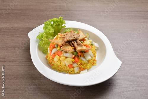 vegetarian nasi goreng fried rice with pineapple, vegetables meat in spicy chilli sambal sauce on wood background asian halal vegan menu