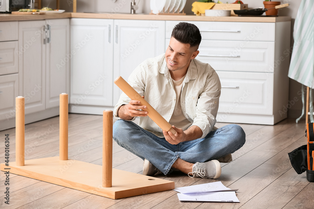 Young man assembling furniture at home Young man assembling furniture at home