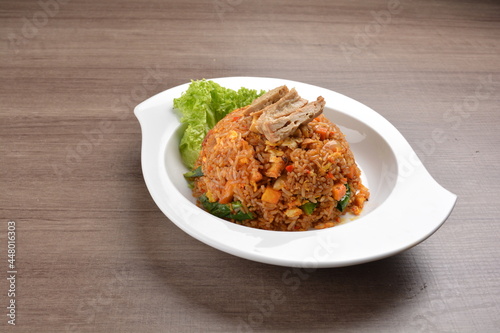 vegetarian nasi goreng fried rice with pineapple, vegetables meat in spicy chilli sambal sauce on wood background asian halal vegan menu
