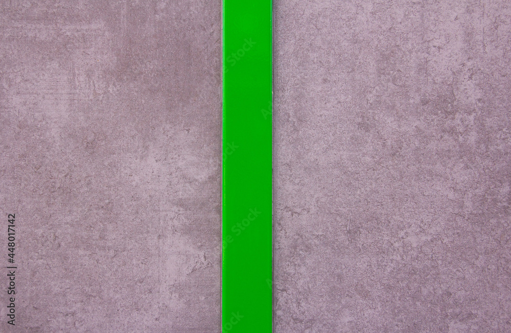 Fototapeta premium Gray wall texture with polished green stripe in the center. Background. Modern design.
