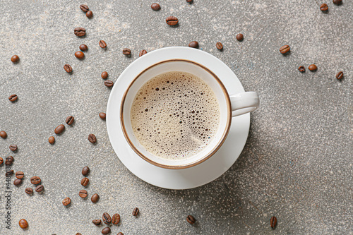 Cup of coffee and beans on grunge background