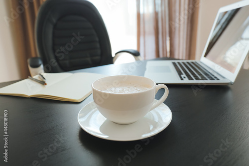 Cup of coffee on table in office, closeup