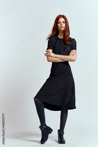 cute red-haired woman in black dress dispensing studio lifestyle