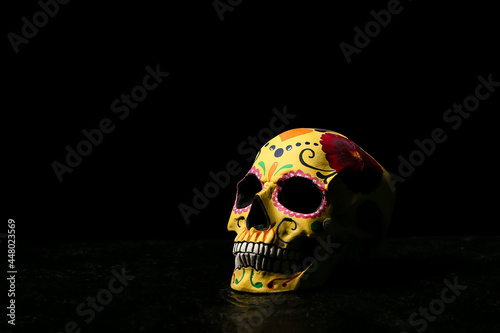 Photography Painted human skull for Mexico's Day of the Dead (El Dia de Muertos) on dark bac