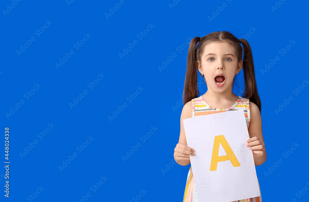 Little girl holding paper sheet with letter A on color background Little girl holding paper sheet with letter A on color background