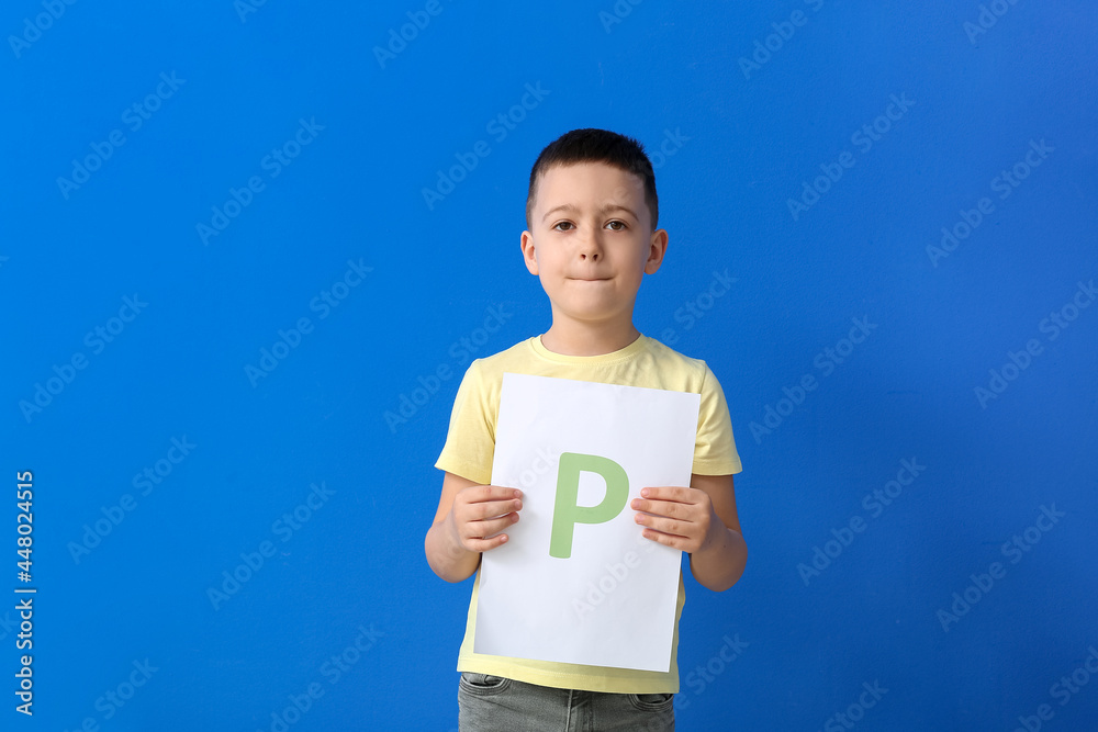 Little boy holding paper sheet with letter P on color background