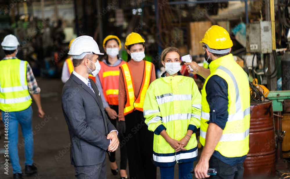 Temperature measurement with employee temperature meter before entering work at factory. Professional engineering team. Temperature measurement with employee temperature meter before entering work at factory. Professional engineering team.