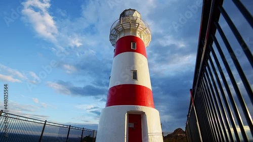 A low angle of a Cape Palliser Lighthouse, New Zealand, North Island, near Wellington with a cloudy background photo