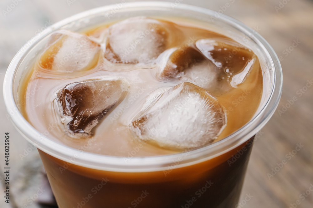 Plastic cup of ice coffee on wooden background, closeup Plastic cup of ice coffee on wooden background, closeup
