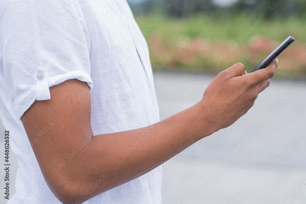 Close up of hands of African American man with a smartphone. Freelance, working, touching, typing