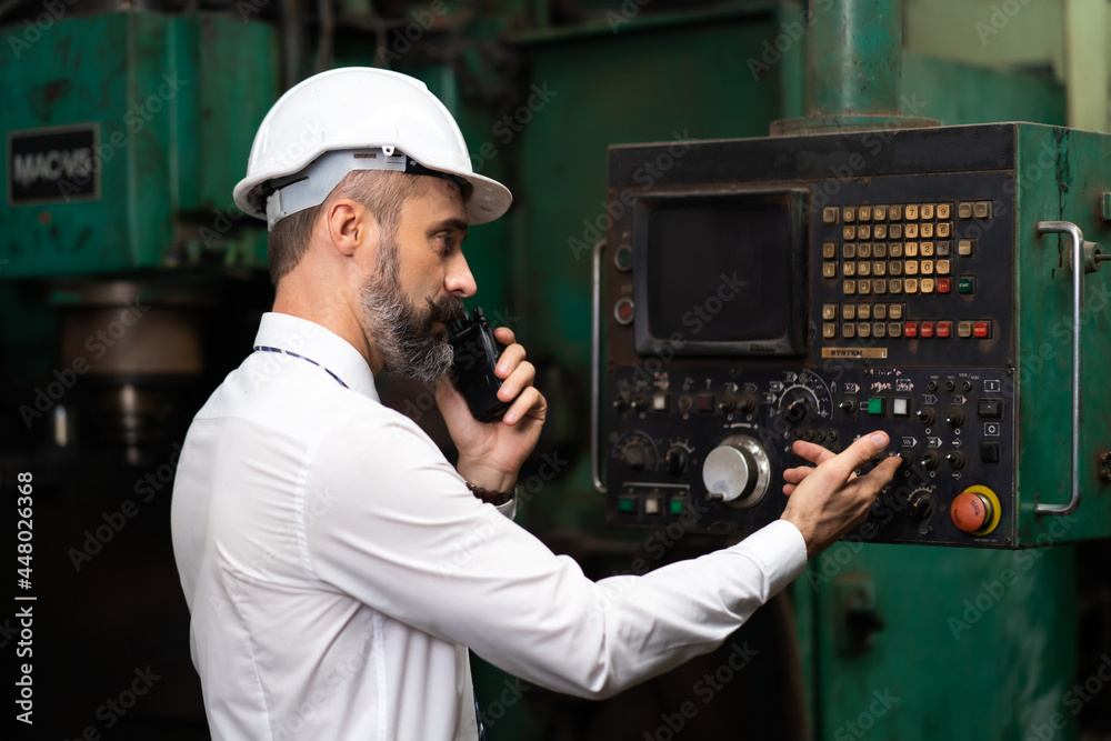 Man at work. Mechanical Engineer Bearded man in Hard Hat in Heavy Industry Manufacturing Facility. Professional Engineer Operating lathe Machinery Man at work. Mechanical Engineer Bearded man in Hard Hat in Heavy Industry Manufacturing Facility. Professional Engineer Operating lathe Machinery