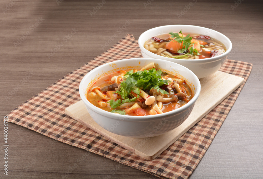 cook hot and spicy tom yum soup with mushroom and mixed vegetables in white bowl on wood background asian halal vegan menu cook hot and spicy tom yum soup with mushroom and mixed vegetables in white bowl on wood background asian halal vegan menu