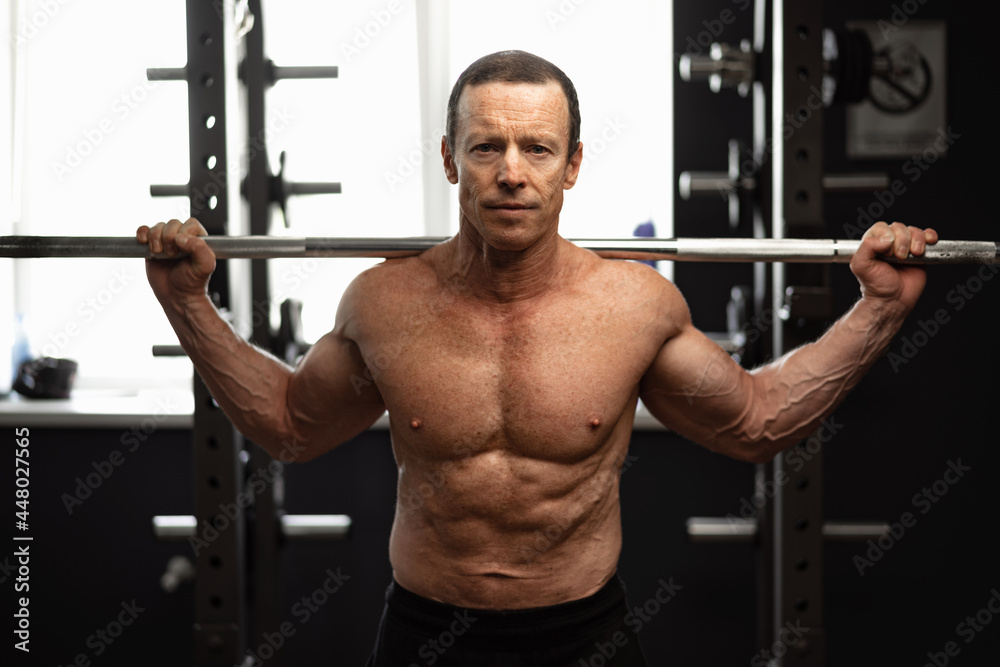Senior man working out at the gym doing squats Senior man working out at the gym doing squats