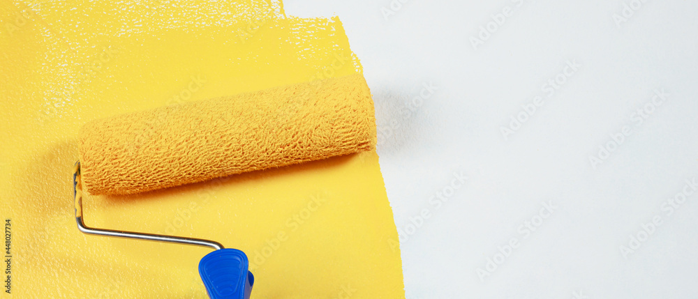 Obraz premium Painter is painting the interior wall yellow