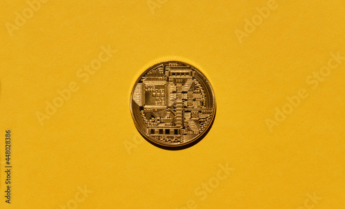 Crypto currency. Bitcoin physical coin on yellow background.
