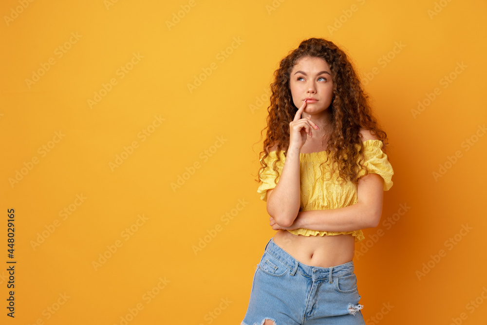 Portrait of young curly woman thinking and looks left Portrait of young curly woman thinking and looks left