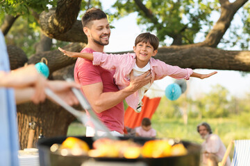 Happy family at barbecue party on summer day