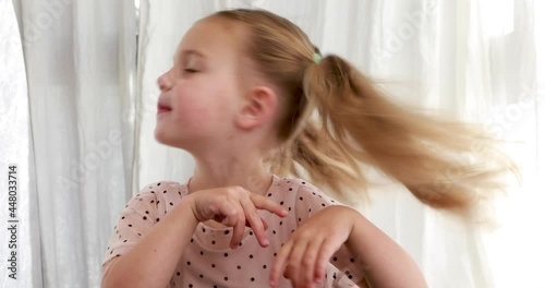 Funny little girl shakes head in denial. Happy cute child expresses disagreement, says no close-up