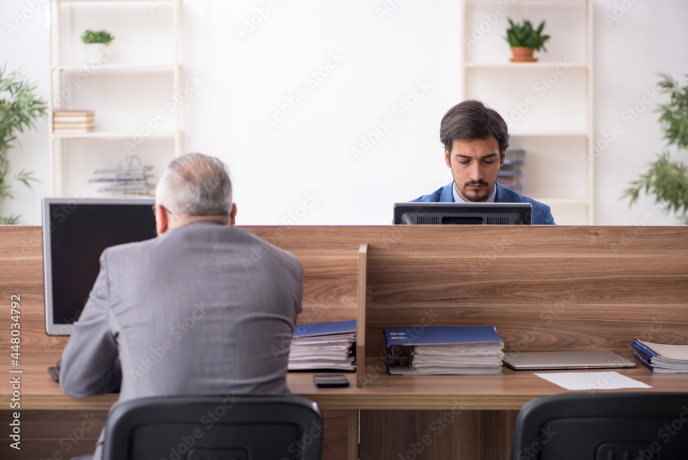 Two male employees working in the office Two male employees working in the office