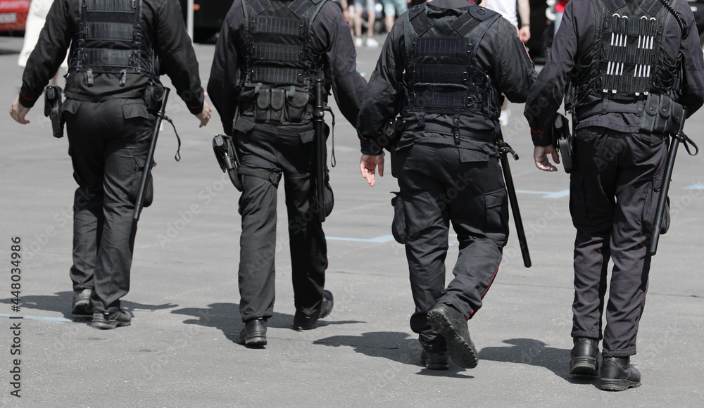 patrol of 4 policemen with truncheons and guns that control the city patrol of 4 policemen with truncheons and guns that control the city