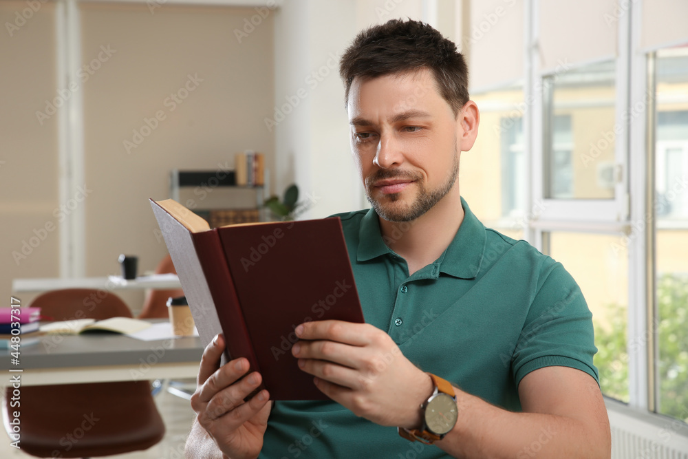 Handsome man reading book in university library Handsome man reading book in university library
