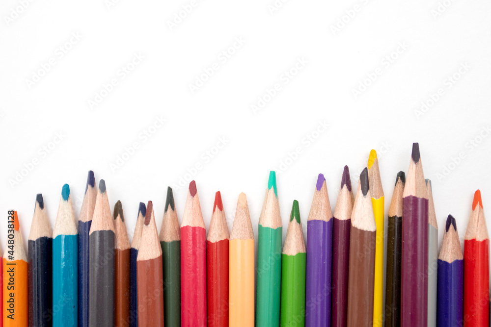Multi-colored pencils row on a white background Multi-colored pencils row on a white background