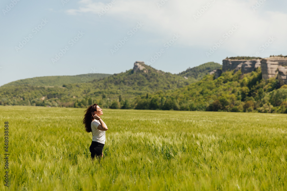 woman looks at the view in the field of wheat harvest