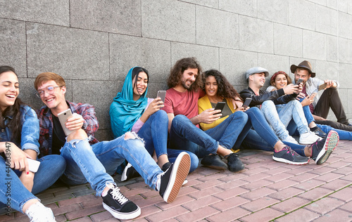 Young multiracial group of friends using mobile smartphone outdoor - Youth millennial lifestyle concept
