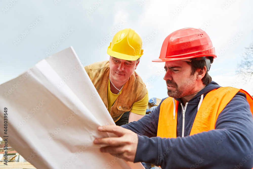 Bauarbeiter und Architekt schauen auf Bauzeichnung Bauarbeiter und Architekt schauen auf Bauzeichnung